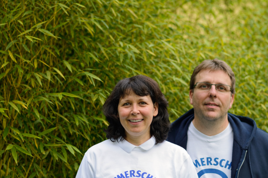 Personal Trainer Petra und Ralf vor grünem bepflanztem Hintergrund